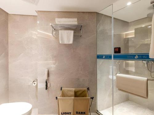 a bathroom with a toilet and a glass shower at Dalian Bohai Pearl Hotel in Dalian