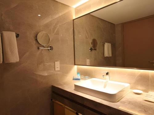 a bathroom with a sink and a mirror at Dalian Bohai Pearl Hotel in Dalian