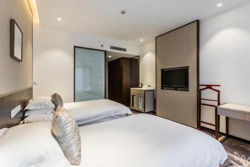 a hotel room with two beds and a tv at International Conference Hotel Nanjing in Nanjing