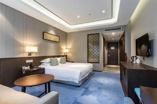 a hotel room with a bed and a television at International Conference Hotel Nanjing in Nanjing
