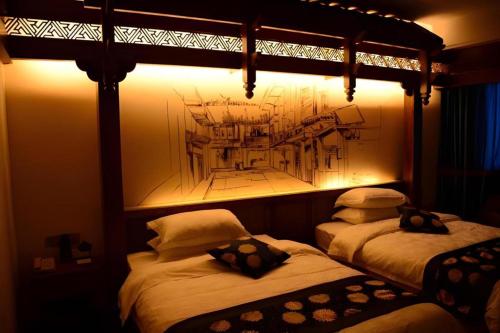 two beds in a room with a drawing on the wall at Zhangjiajie Xiangfu International Hot Springs Hotel in Zhangjiajie