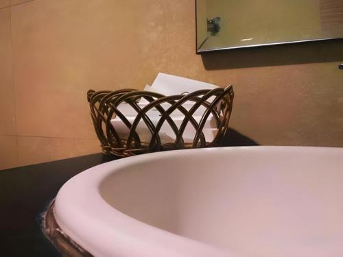 a bathroom with a white sink and a basket at Muria Hotel in Semarang