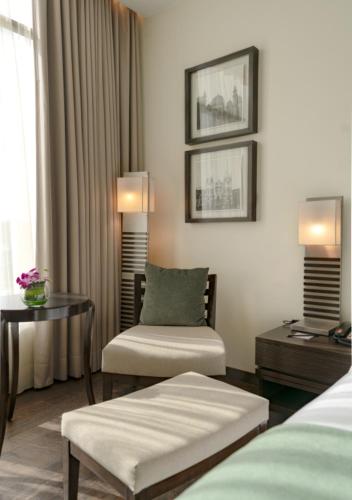 a hotel room with a bed and a chair and a table at The Mirador in Mumbai