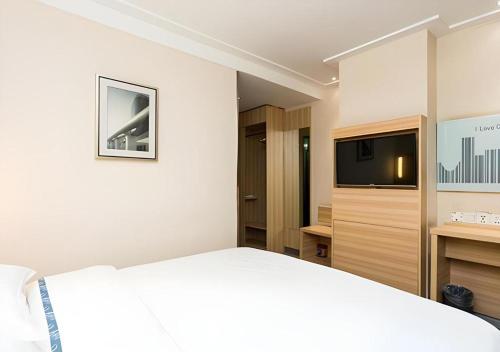 a hotel room with a bed and a television at City Comfort Inn Xiangyang Railway Station in Xiangyang