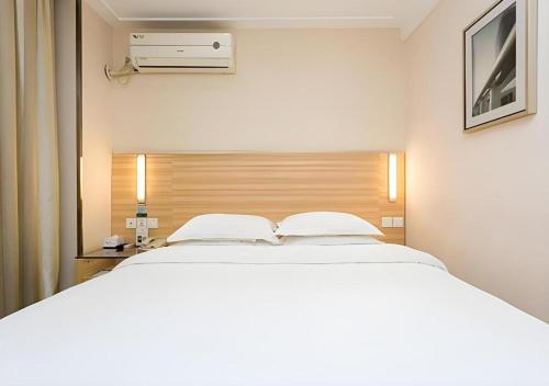 a bedroom with a large white bed in it at City Comfort Inn Xiangyang Railway Station in Xiangyang