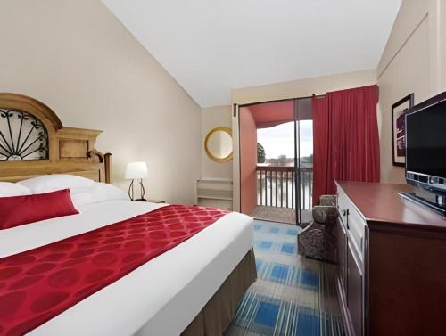 a hotel room with a large bed and a television at Ramada by Wyndham Monument in Monument