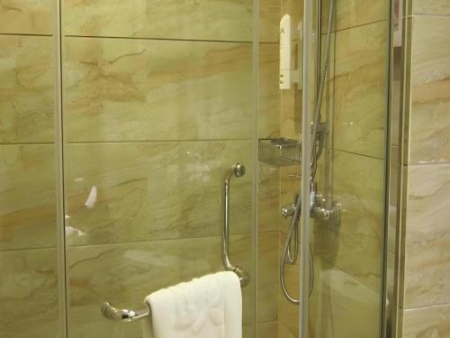 a bathroom with a shower with a glass door at Shaanxi Business Hotel in Shanghai