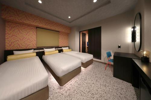 a hotel room with two beds and a desk and a desk at Nipponbashi Luxe Hotel in Osaka