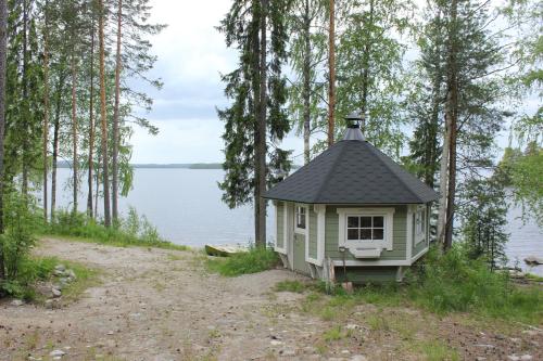 a small house on the side of a body of water at Lake Cottage Jänisvaara in Kolinkylä