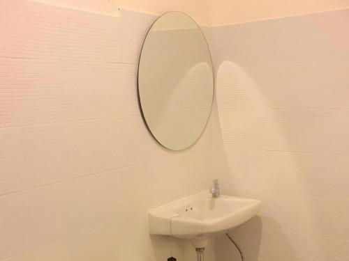 a bathroom with a sink and a mirror on the wall at Le Bar Tarry Hotel in Loei