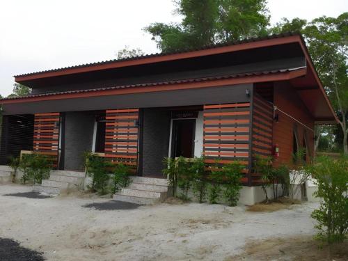 a small house with wooden shutters on it at Wanghin Bungalow in Surat Thani