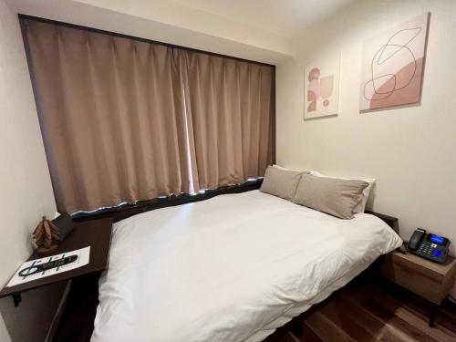 a bedroom with a white bed and a window at daren stay in Tokyo