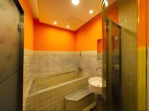 a bathroom with a sink and a tub and a toilet at Dalian Household Theme Hotel Huanghe Road Branch in Dalian