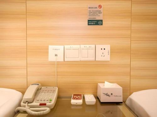 a room with a phone and other items on a table at City Comfort Inn Wuhan Hankou Railway Station West Square in Wuhan
