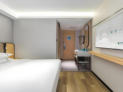 a hotel room with a bed and a projection screen at City Comfort Inn Wuhan Hankou Railway Station West Square in Wuhan