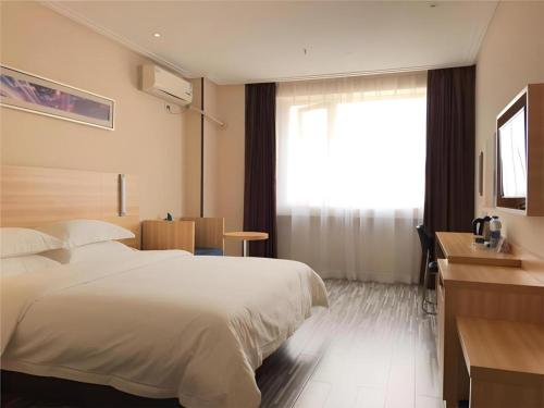 a hotel room with a bed and a window at City Comfort Inn Wuhan Hankou Railway Station West Square in Wuhan