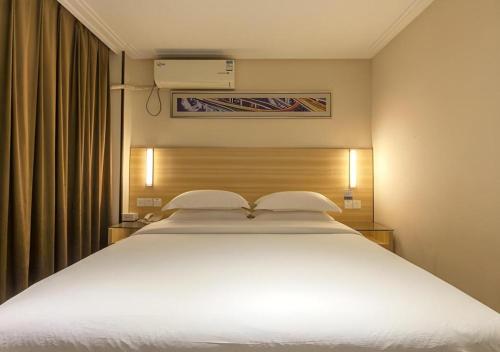 a large white bed in a hotel room at City Comfort Inn Wuhan Hankou Railway Station West Square in Wuhan