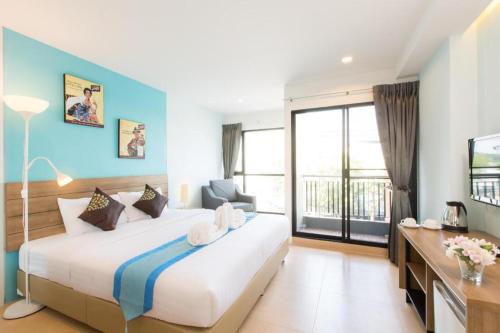 a bedroom with a large bed and a large window at Viva Residence in Ban Baen Phichit