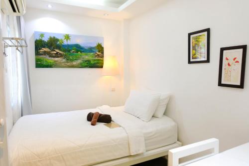 a bedroom with a bed with a teddy bear on it at Baanpoon Apartment in Chaweng
