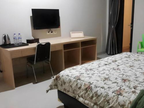 a bedroom with a desk with a computer and a bed at Fafa Hill Hotel and Resort in Bogor