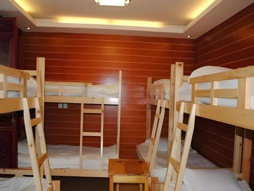 a room with three bunk beds in a room at Lijiang Peach Hostel in Lijiang