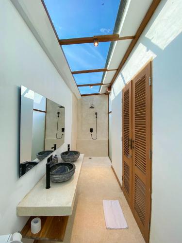 a bathroom with two sinks and a skylight at Maravilla Complex in Nusa Penida
