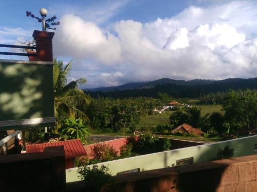 a view from the balcony of a house with mountains in the background at Green Villa in Virajpet