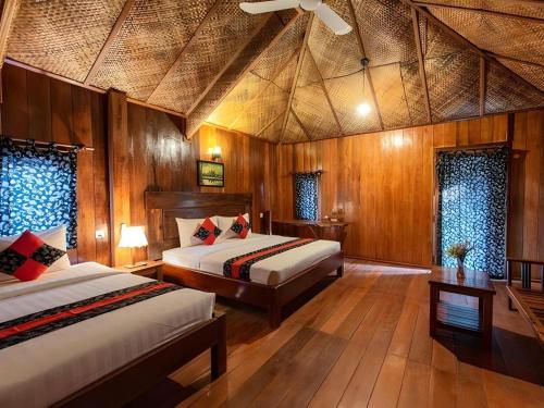 a bedroom with two beds and a ceiling at Amour D' Angkor in Phumĭ Réach Born (1)