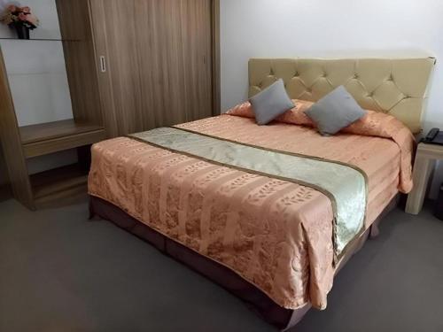 Schlafzimmer mit einem großen Bett mit Kopfteil in der Unterkunft Score Birds Hotel in Angeles