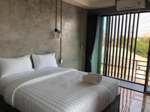 a bedroom with a large bed with a large window at Sixty-nine Resort in Ban Tha Khwai