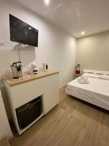 a bedroom with a bed and a tv on the wall at AmaRé House in Bari