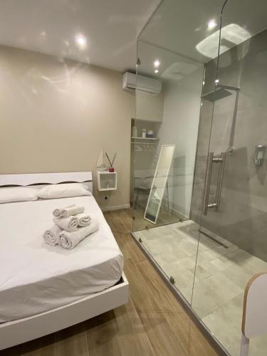 a bedroom with a shower and a bed with towels at AmaRé House in Bari