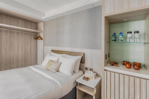 a bedroom with a bed and a dresser at Stanford Hillview Hotel Hong Kong in Hong Kong