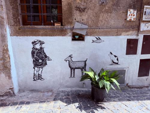 a wall with a painting of a girl and animals at Gabriella's in Capranica