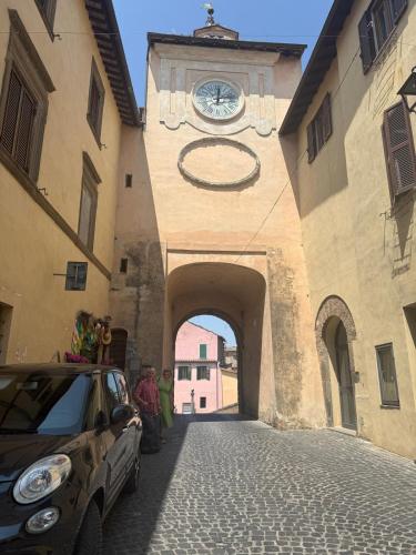a car parked next to a building with a clock tower at Gabriella's in Capranica
