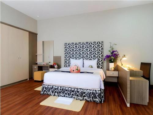 - une chambre dotée d'un grand lit avec une tête de lit noire et blanche dans l'établissement Bali Rich Villa, à Tuban