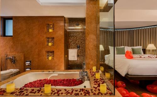 a bathroom with a bath tub filled with red roses at The Mirador in Mumbai