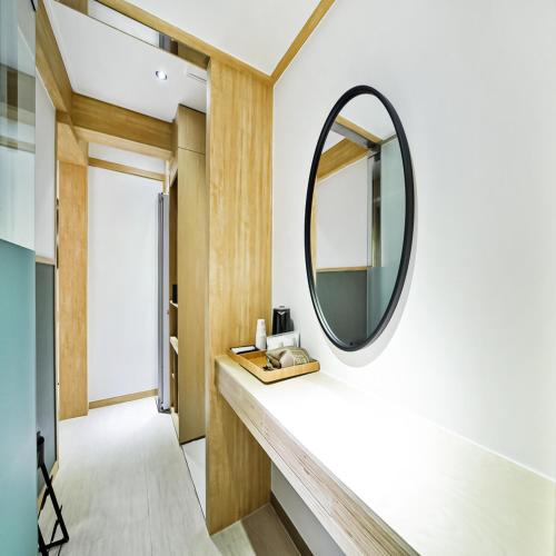 a mirror on a wall next to a hallway at No 25 Hotel Gumi Wonpyeongdong in Gumi