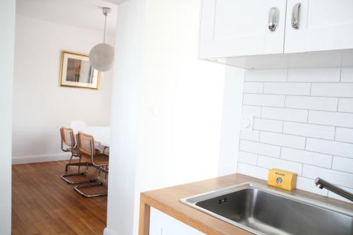 une cuisine avec un évier et une table avec des chaises dans l'établissement Gwaskedou, sea view, beach and city center, à Roscoff