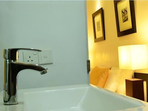 ein Waschbecken mit einem Wasserhahn und einem Spiegel in der Unterkunft 26 Loversleap Cottage in Nuwara Eliya