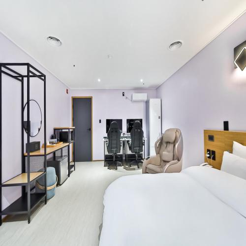 a hotel room with a bed and a desk and chairs at No 25 Hotel Gumi Wonpyeongdong in Gumi