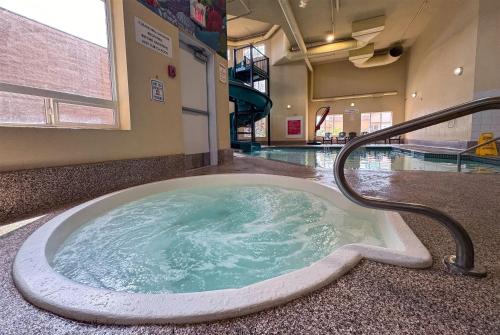a jacuzzi tub in a building with a swimming pool at Super 8 by Wyndham Edmonton South in Edmonton