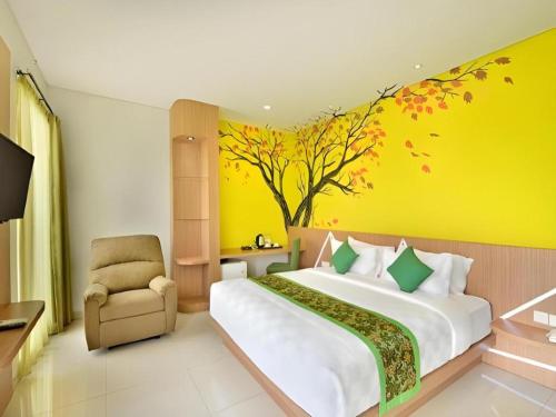 a bedroom with a large bed and a tree mural at Lotus Hotel Subang in Bandung