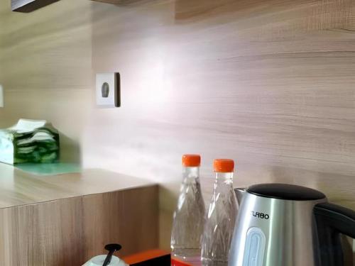 a kitchen counter with a coffee maker and two bottles at GARDEN HOTEL MAJALENGKA in Majalengka