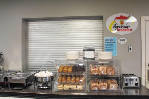 a bakery counter with donuts and other pastries at Super 8 by Wyndham Edmonton South in Edmonton