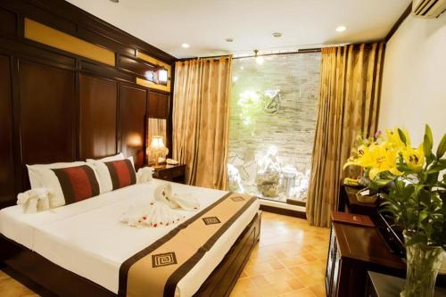 a bedroom with a large bed and a window at Aquarius Hotel in Hanoi