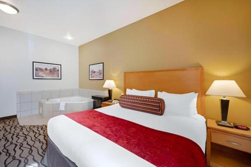 a hotel room with a bed and a bath tub at Best Western Plus Guymon Hotel and Suites in Guymon