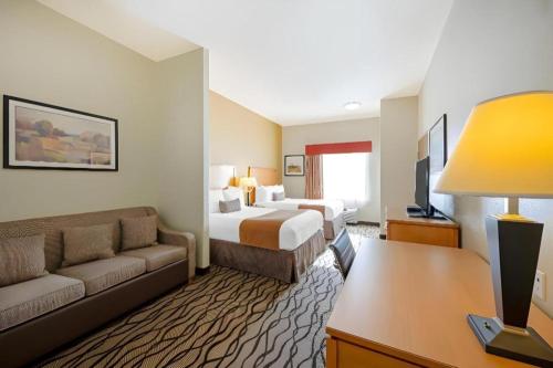 a hotel room with a bed and a couch at Best Western Plus Guymon Hotel and Suites in Guymon