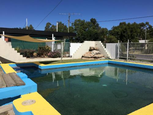 a swimming pool in a yard with a fence at Boggabilla Motel in Boggabilla
