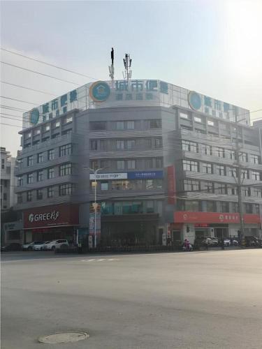 a large building on the corner of a street at City Comfort Inn Dangtu High Speed East Railway Station RT-Mart in Ma'anshan
